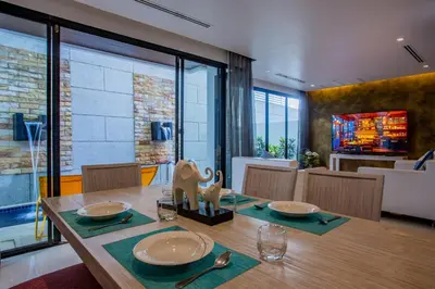 a dining room with a wooden table with chairs and a dining room at Naiharn Pool Villa Number 5 in Rawai Beach