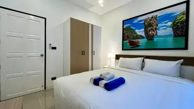 a bedroom with a white bed with a large painting on the wall at Bayok 10 - 2 Bedroom Villa Near Kathu Waterfall in Ban Huai Luk (1)
