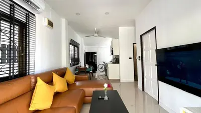 a living room with a brown couch and yellow pillows at Bayok 10 - 2 Bedroom Villa Near Kathu Waterfall in Ban Huai Luk (1)