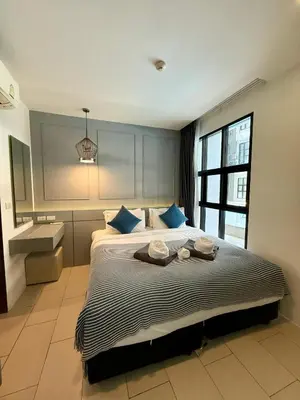a bedroom with a large bed with blue pillows at Poolside 1 Bedroom Apartment by Renttini in Surin Beach