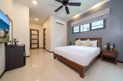 a bedroom with a bed and a ceiling fan at Onyx 2 br private pool Rawai in Ban Saiyuan (1)