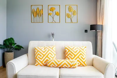 a living room with a white couch with yellow and white pillows at Apart Close to the Beach Sea view in Rawai Beach