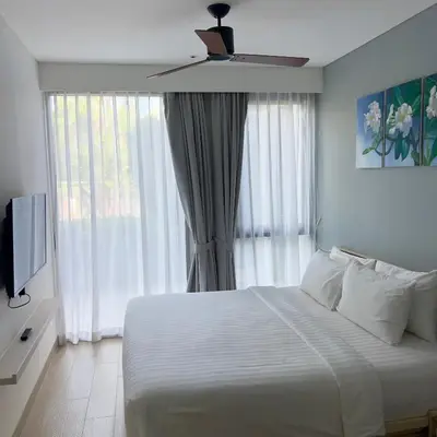 a bedroom with a white bed and a window at Cassia Phuket laguna 1 BDR in Laguna Phuket