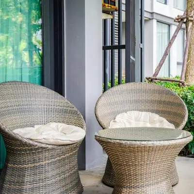 two wicker chairs and a table on a porch at Cassia Phuket laguna 1 BDR in Laguna Phuket