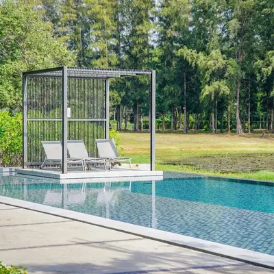 a gazebo with two chairs next to a pool at Cassia Phuket laguna 1 BDR in Laguna Phuket