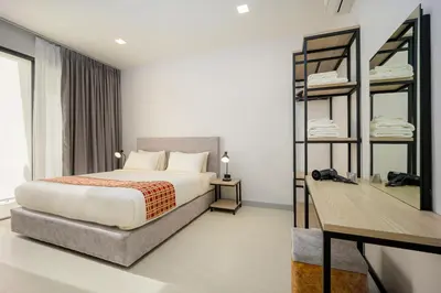 a bedroom with a bed and a desk in it at Barringtonia pool villa in Phuket Town