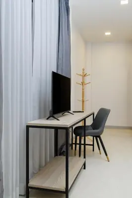 a desk with a monitor and a chair in a room at Barringtonia pool villa in Phuket Town