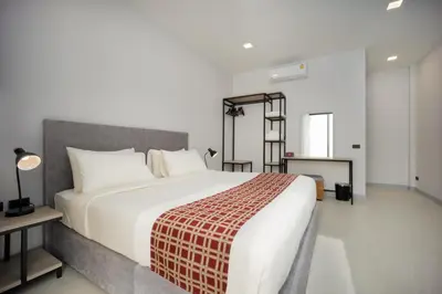 a bedroom with a large white bed and a ladder at Barringtonia pool villa in Phuket Town