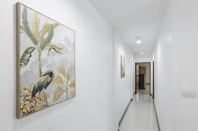 a hallway with a painting of birds on the wall at PMS Boutique Patong in Patong Beach