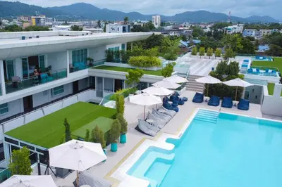 an image of a hotel with a pool and umbrellas at Chalong Marina Bay View Phuket in Rawai Beach