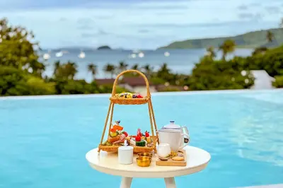 a tray with a tea set on a table next to a pool at Chalong Marina Bay View Phuket in Rawai Beach