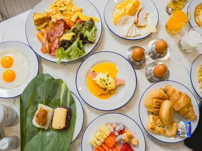a table with plates of breakfast foods on it at Chalong Marina Bay View Phuket in Rawai Beach