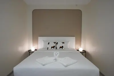 a white bed with three cats and a bow on it at Hommory Residence - East Chalong in Phuket Town