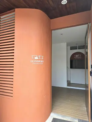 an orange wall with a sign on the side of a building at Hommory Residence - East Chalong in Phuket Town