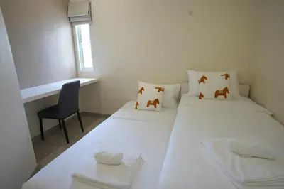 two beds in a small room with a chair at Hommory Residence - East Chalong in Phuket Town