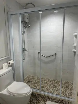 a bathroom with a glass shower with a toilet at Patong Tower Apartments sea view 2B in Patong Beach