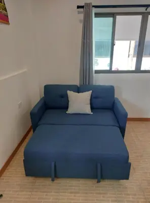 a blue couch in a room with a window at Smile house in Karon Beach