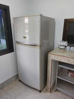 a white refrigerator in a kitchen next to a counter at Smile house in Karon Beach
