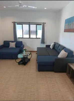 a living room with a blue couch and a table at Smile house in Karon Beach