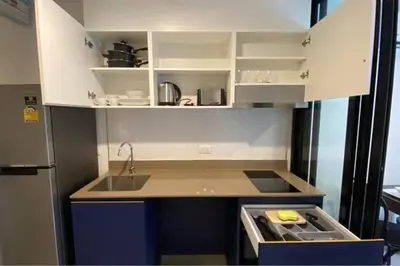 a small kitchen with white cabinets and a sink at Mode apartment central Phuket in Phuket Town