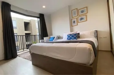 a bedroom with a large bed and a balcony at Mode apartment central Phuket in Phuket Town