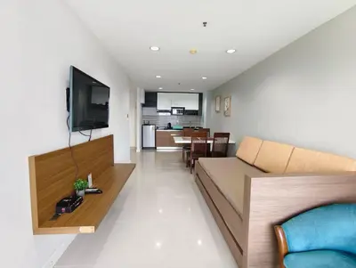 a living room and kitchen with a couch and a television at Patong tower sea view in Patong Beach