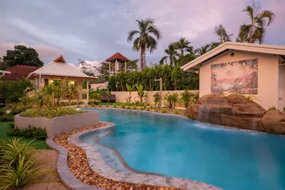 a swimming pool in front of a house with a resort at The Hidden Lagoon Resort - Exclusively for Adults in Rawai Beach
