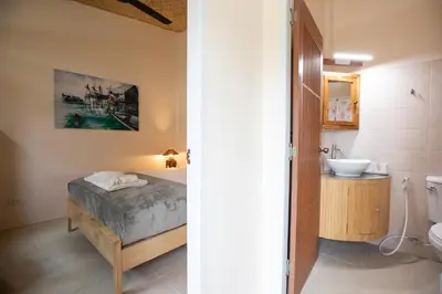a bathroom with a bed and a sink in a room at The Hidden Lagoon Resort - Exclusively for Adults in Rawai Beach