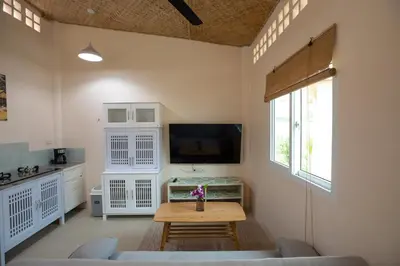 a living room with a table and a tv at The Hidden Lagoon Resort - Exclusively for Adults in Rawai Beach