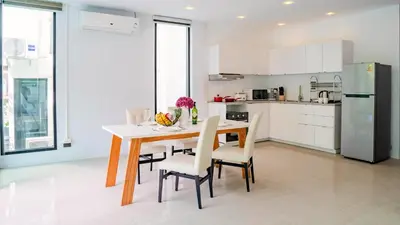a kitchen with a table and chairs and a refrigerator at Lively Stay at Vibrant Kata, 4BR Pool Villa B2 near Beach - UTK2 in Kata Beach
