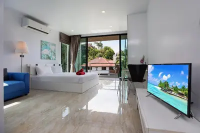 a living room with a bed and a flat screen tv at Lively Stay at Vibrant Kata, 4BR Pool Villa B2 near Beach - UTK2 in Kata Beach