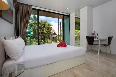 a bedroom with a large white bed and a table at Lively Stay at Vibrant Kata, 4BR Pool Villa B2 near Beach - UTK2 in Kata Beach