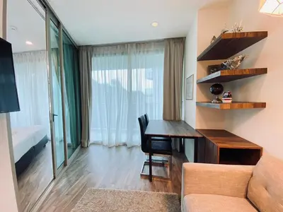 a living room with a table and a couch at A11 Oceana Kamala in Kamala Beach