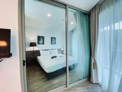 a bedroom with a bed and a large glass window at A11 Oceana Kamala in Kamala Beach