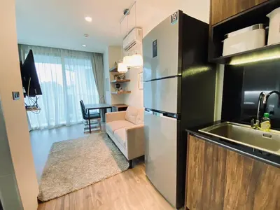 a kitchen with a stainless steel refrigerator and a table at A11 Oceana Kamala in Kamala Beach