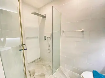 a bathroom with a glass shower with a toilet at A11 Oceana Kamala in Kamala Beach