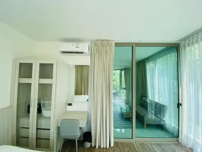 a bedroom with a bed and a room with a window at A26 Oceana Kamala in Kamala Beach