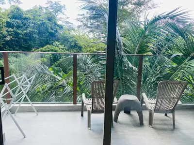 two chairs sitting on a balcony with palm trees at A26 Oceana Kamala in Kamala Beach