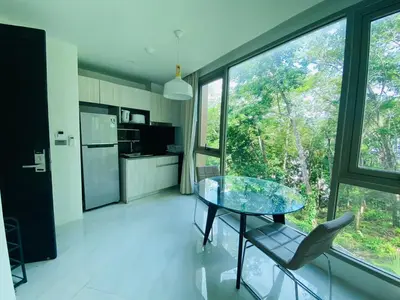 a kitchen with a glass table and a chair at A26 Oceana Kamala in Kamala Beach
