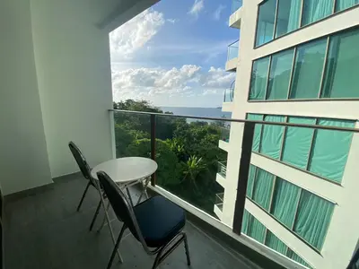 a balcony with a table and chairs and a view of the ocean at A43 Oceana kamala in Kamala Beach