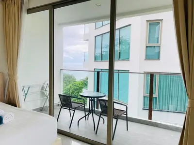 a bedroom with a balcony with a table and chairs at A45 Oceana Kamala in Kamala Beach