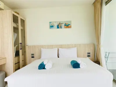 a bedroom with a white bed with blue towels on it at A45 Oceana Kamala in Kamala Beach