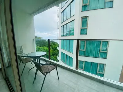 a balcony with a table and chairs and a large window at A45 Oceana Kamala in Kamala Beach