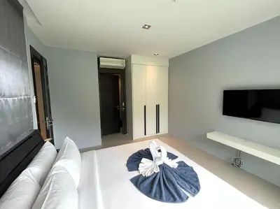 a living room with a white couch and a flat screen tv at Private sea view apartment at Emerald Terrace in Patong Beach