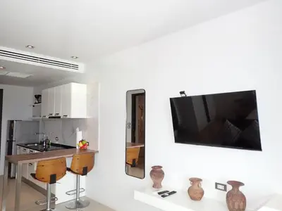 a white kitchen with a tv on a wall at Private sea view apartment at Emerald Terrace in Patong Beach