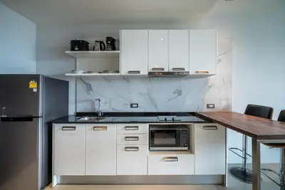 a kitchen with white cabinets and a counter with a microwave at Private sea view apartment at Emerald Terrace in Patong Beach