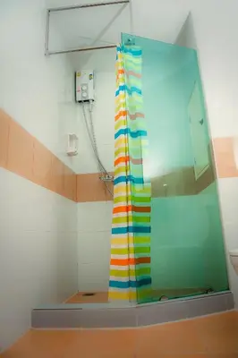 a shower with a colorful shower curtain in a bathroom at KC Kamala Guesthouse in Kamala Beach