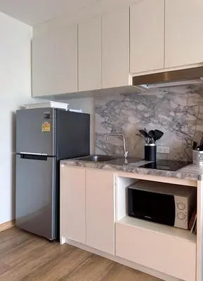 a kitchen with white cabinets and a stainless steel refrigerator at Aristo-2-805 in Surin Beach