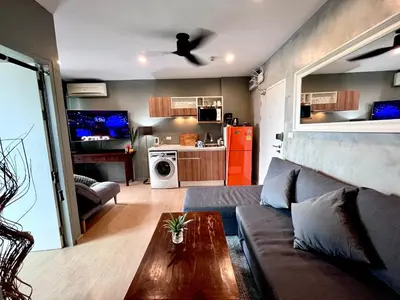 a living room with a couch and a table at ZcapeX2 condominium in Bang Tao Beach