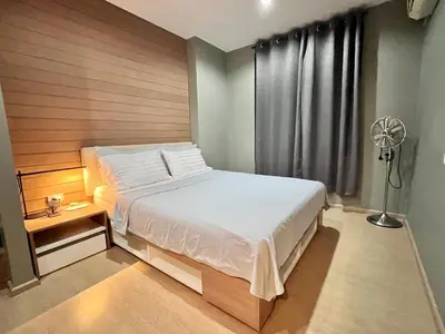 a bedroom with a large bed and a fan at ZcapeX2 condominium in Bang Tao Beach